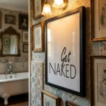 Get Naked print in black wooden frame in bathroom
