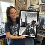Diplomatic Immunity Alien Art Print held by young woman