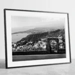 Framed Taormina Bay Sicily black and white digital wall art print by Mark Marsh, showing the freestanding stone archway and wrought-iron gate detail.