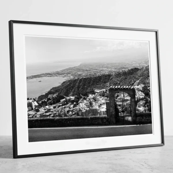 Bay of Naxos from Via Madonna della Rocca digital print framed Framed Taormina Bay Sicily black and white digital wall art print by Mark Marsh, showing the freestanding stone archway and wrought-iron gate detail.