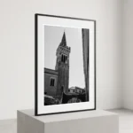 Taormina Campanile black and white digital download print in a black frame, styled in a hallway or stairwell with stone textures, capturing the Sicilian bell tower by Mark Marsh.