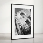 Framed Taormina Corso Umberto black and white digital wall art print by Mark Marsh, showing the round glass clock window and ornate wrought-iron balcony detail.