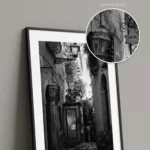 Close-up of a framed Taormina DIOR alley black and white digital wall art print by Mark Marsh, showing the glass display case, cherub sculpture, and wrought-iron sign detail.