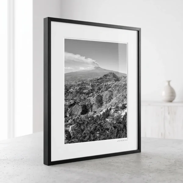 Etna Eruption from Taormina digital print by Mark Marsh in A4 frame Mount Etna smoke plume black and white digital download print in a black frame, styled in a living room or study with concrete and stone textures, capturing the Sicilian volcano by Mark Marsh.