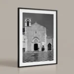 Framed black and white printable art of the ex Chiesa di Sant'Agostino in Taormina, Sicily—Gothic facade above the checkered floor of Piazza IX Aprile, captured by Mark Marsh and displayed on a beige background.