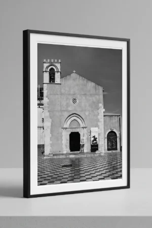 Sant'Agostino Taormina black and white digital download print in a black frame, styled on a shelf with stone textures, capturing Sicilian Gothic architecture by Mark Marsh.