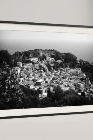 Framed Taormina rooftops black and white digital wall art print by Mark Marsh, showing the historic stone facades, terracotta tiles, and Ancient Theatre carved into the hillside detail.
