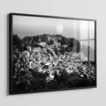 Framed black and white printable art of Taormina rooftops in Sicily—a dense sea of terracotta tiles with the Ancient Theatre carved into Mount Tauro, captured by Mark Marsh.