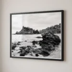 Framed Isola Bella black and white digital wall art print by Mark Marsh, showing the porous volcanic tide pool rocks and the distant islet vegetation detail.