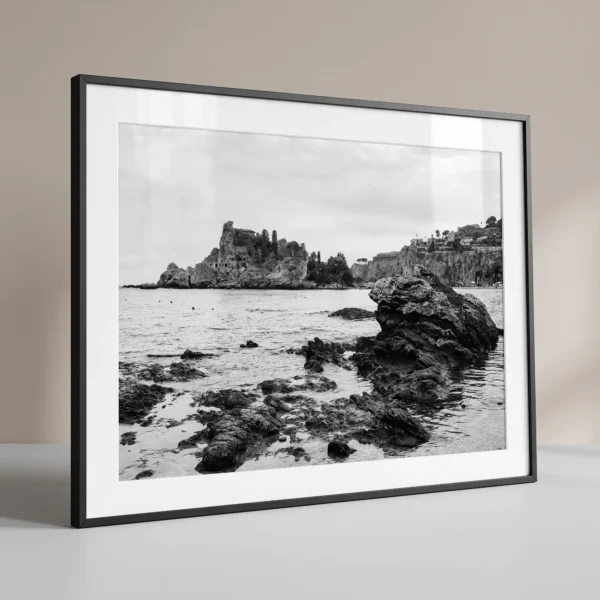 Isola Bella Printable Art printed at A3 Size Isola Bella black and white digital download print in a black frame, styled with natural stone textures, capturing the Sicilian coast by Mark Marsh.