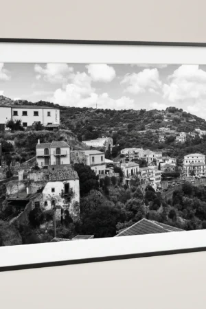 Framed Savoca Sicily black and white digital wall art print by Mark Marsh, showing the crumbling stone houses, traditional balconies, and layered village detail.