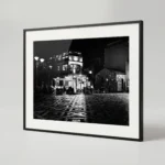 , styled in a bedroom or living room with warm wood and stone textures, capturing Sicilian village night by Mark Marsh. Keywords for SEO Primary: Castelmola printable art, Sicily black and white print, Piazza Sant'Antonino, digital wall art Sicily, Italian village print, monochrome nocturne print, Sicily digital download Secondary: Antico Caffè San Giorgio, Piazza Belvedere, Sicilian village night, mosaic floor art, Mediterranean piazza print, atmospheric travel art Long-tail: black and white print of Castelmola piazza, Piazza Sant'Antonino night photo, printable Italian village wall art, monochrome Sicilian nocturne photography, Castelmola piazza print download Brand: Mark Marsh, Neurodecorating, The Art of Digital Living, Sicily in Black & White collection.