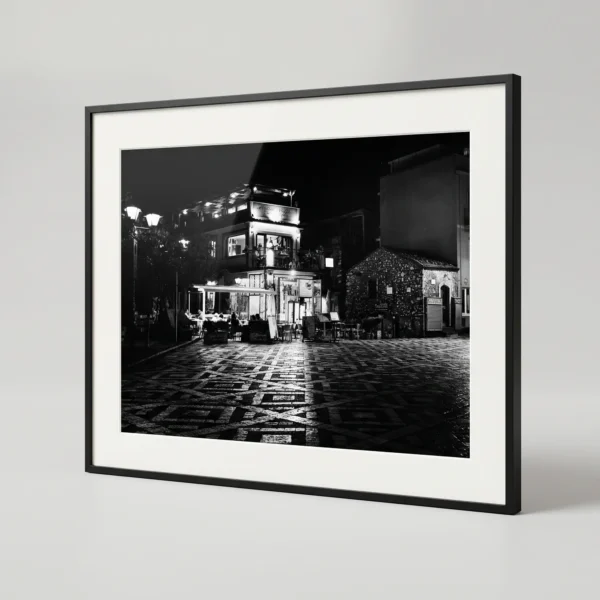 Piazza Sant'Antonino black and white digital download by Mark Marsh in black frame , styled in a bedroom or living room with warm wood and stone textures, capturing Sicilian village night by Mark Marsh. Keywords for SEO Primary: Castelmola printable art, Sicily black and white print, Piazza Sant'Antonino, digital wall art Sicily, Italian village print, monochrome nocturne print, Sicily digital download Secondary: Antico Caffè San Giorgio, Piazza Belvedere, Sicilian village night, mosaic floor art, Mediterranean piazza print, atmospheric travel art Long-tail: black and white print of Castelmola piazza, Piazza Sant'Antonino night photo, printable Italian village wall art, monochrome Sicilian nocturne photography, Castelmola piazza print download Brand: Mark Marsh, Neurodecorating, The Art of Digital Living, Sicily in Black & White collection.