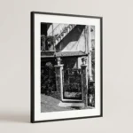 Framed Castelmola Testa di Moro black and white digital wall art print by Mark Marsh, showing the male and female ceramic heads and wrought-iron gate detail.