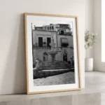 Framed black and white printable art of the Fontana di Piazza Duomo in Taormina, Sicily—crowned centaur statue atop a Baroque Syracuse stone fountain, captured by Mark Marsh and displayed in a modern interior.