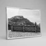 Framed black and white printable art of Monte Veneretta viewed from a stone terrace in Castelmola, Sicily—woven brick balustrade, ceramic planters, and limestone peak beyond, captured by Mark Marsh.