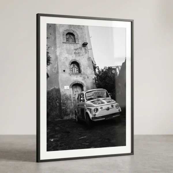 Vintage Fiat 500 parked on a steep stone-paved slope in Castelmola by Mark Marsh Castelmola Fiat 500 black and white digital download print in a black frame, capturing Sicilian street life by Mark Marsh.