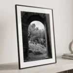 Close-up of a framed Taormina Sicily black and white digital wall art print by Mark Marsh, showing the weathered Roman brick archway and textured prickly pear cacti detail.
