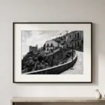 Framed black and white printable art of the winding path to Chiesa di San Nicolò in Savoca, Sicily—Godfather filming location by Mark Marsh, displayed in a modern interior.